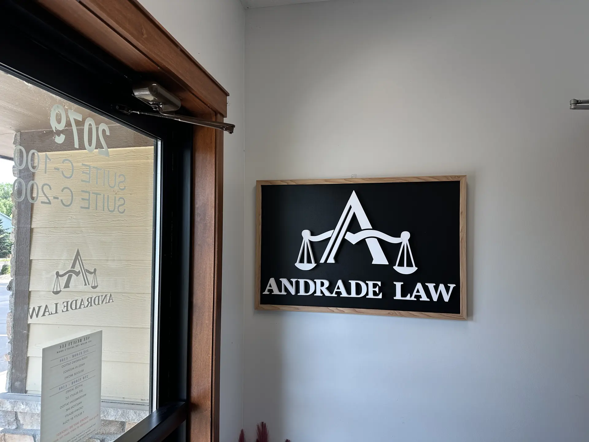 Andrade Law framed logo and office signage at the Maplewood, MN personal injury law office, 2079 County Rd D E