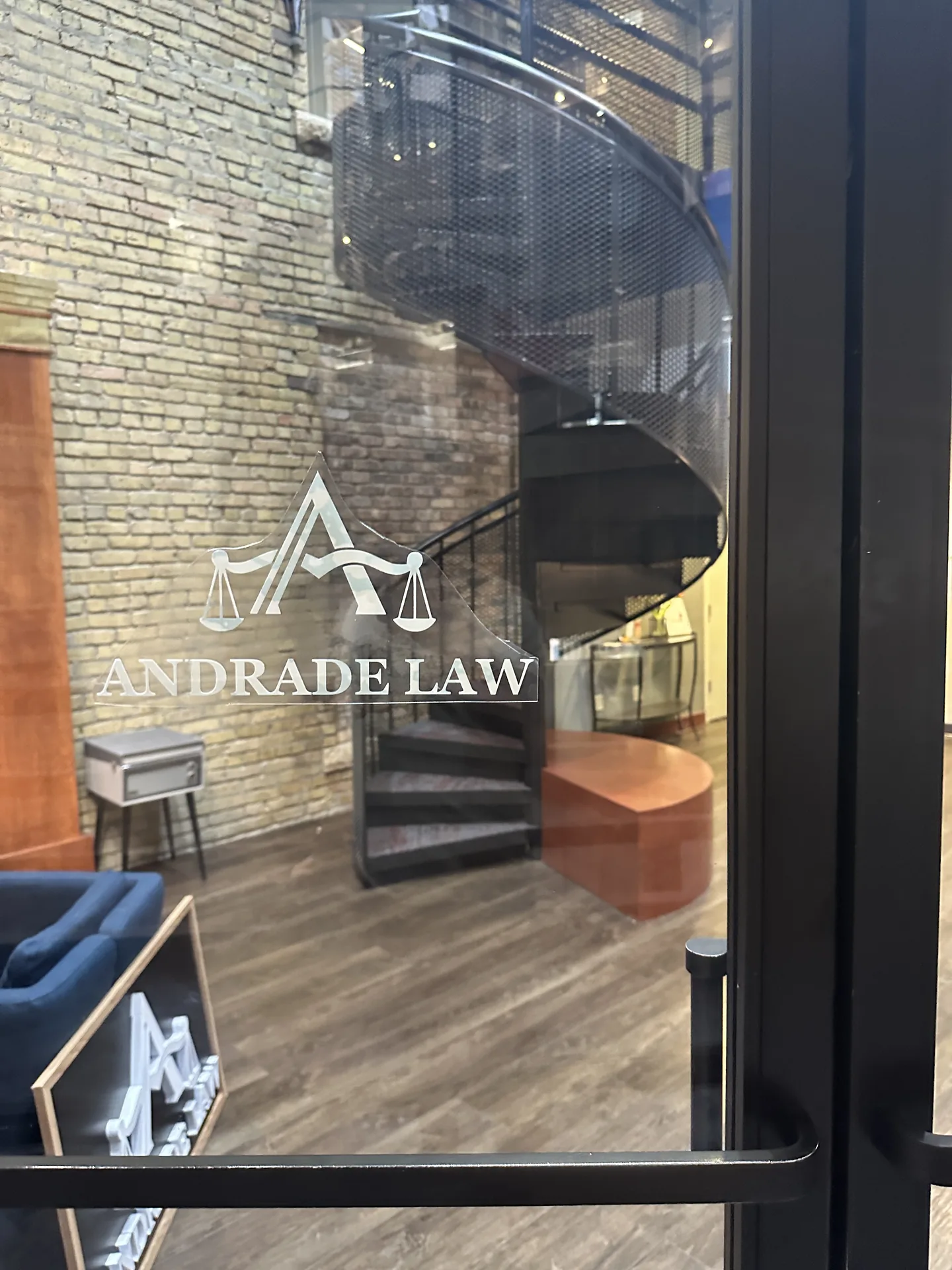 Glass entrance to Andrade Law's Minneapolis office suite at 10 S 5th St Suite 800, with the firm's sign on the door