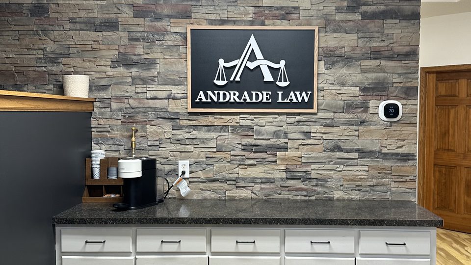 Reception area at Andrade Law in Saint Paul, Minnesota, with the firm's logo on a stone accent wall