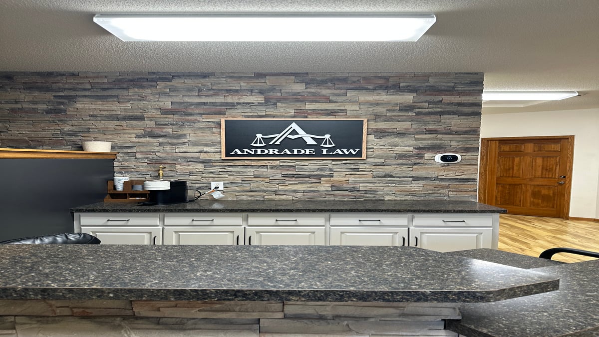 Reception area at Andrade Law in Saint Paul, Minnesota, with the firm's logo on a stone accent wall