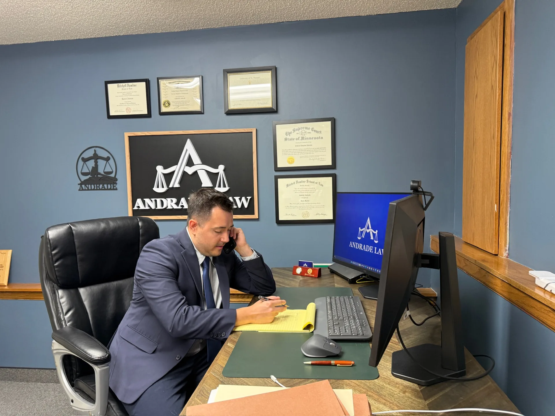 Attorney Gabe Andrade on the phone at his desk in the Andrade Law office in Saint Paul, Minnesota