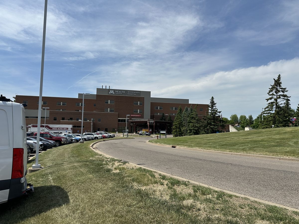 Visitor approach to M Health Fairview Woodwinds Hospital in Woodbury, Minnesota, with the Emergency entrance ahead