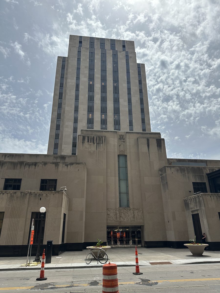 The Fourth Street entrance doors of the Ramsey County Courthouse, set back beneath a carved stone relief panel
