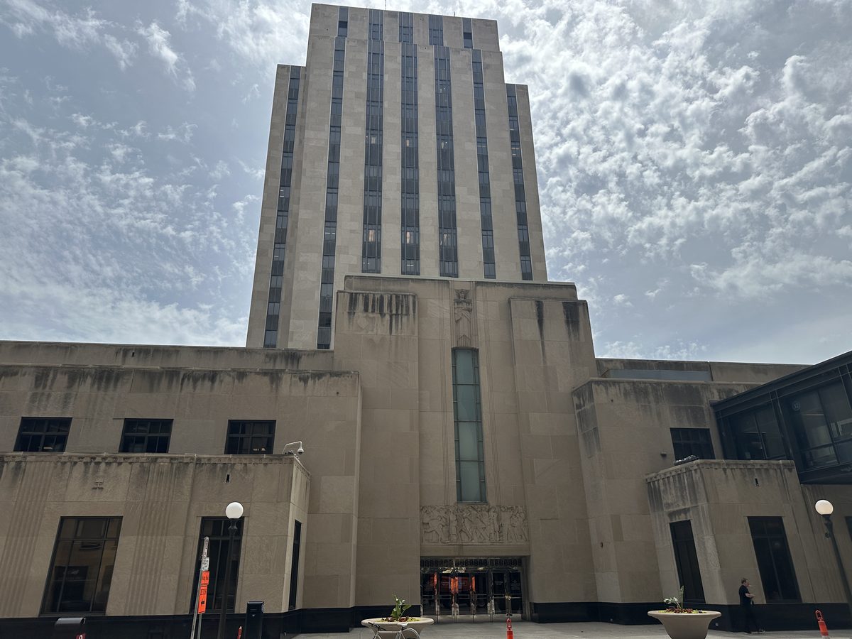 Approach to the Ramsey County Courthouse main entrance, with the carved stone relief above the doors